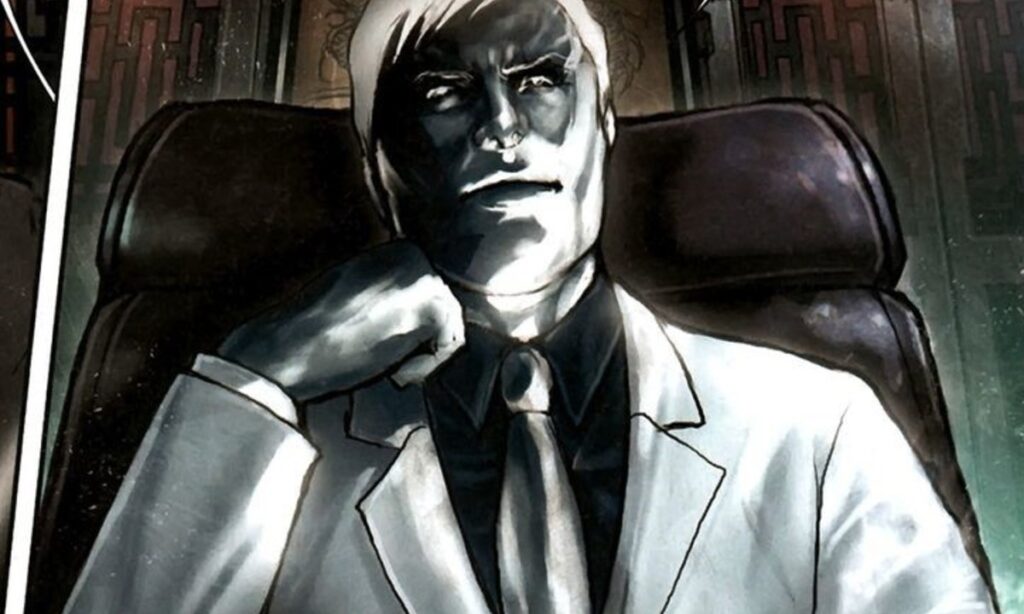 Mister Negative, with his stark white and black appearance, sits thoughtfully in a dark chair.
