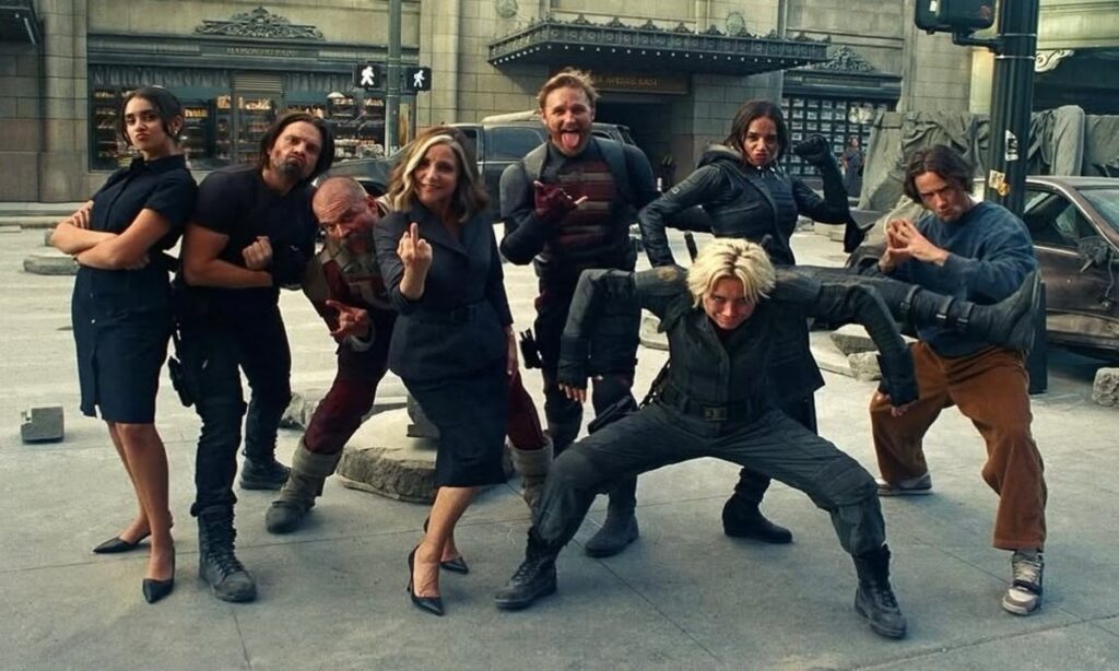 Thunderbolts movie cast pose playfully in costume during behind-the-scenes street set break.