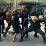 Thunderbolts movie cast pose playfully in costume during behind-the-scenes street set break.
