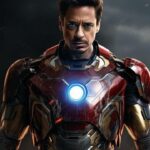 Iron Man in battle-worn suit with glowing arc reactor, standing against a smoky background.