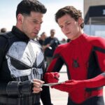 Spider-Man and Punisher intensely discuss justice strategy while reviewing data on a tablet.